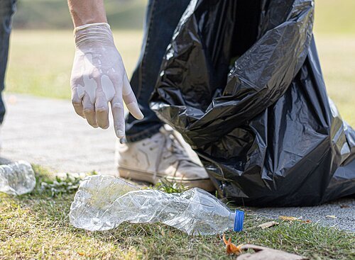 Hand die Müll aufhebt