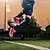 Kind springt mit einem Fußball in die Luft