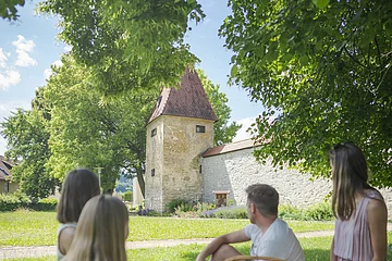 Das Bild zeigt eine Familie beim Picknick in der Heinrich-Herold-Anlage. Im Hintergrund sieht man die Gredinger Stadtmauer mit dem Zeidlerturm.