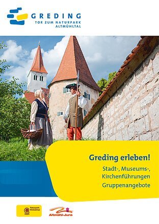 Zwei Personen in historischer Kleidung vor einer Burgmauer und Türmen bei Greding im Altmühltal.
