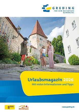 Person in historischer Kleidung zeigt einer Familie mit zwei Kindern einen Turm in Greding, Naturpark Altmühltal.