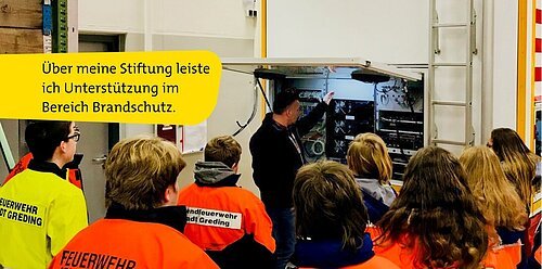 Bürgerstiftung Themenbild Brandschutz Person erklärt einer Gruppe Jugendlicher in Feuerwehrjacken technische Geräte in einem Raum mit Leiter und Tür