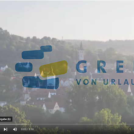 Logo und Schriftzug „Greding von Urlaub umgeben“ vor unscharfer Landschaft mit Häusern und Bäumen