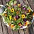 Bunter Salat mit essbaren Blüten auf weißem Teller neben weißem Krug mit Kräuterdressing auf Holztisch.